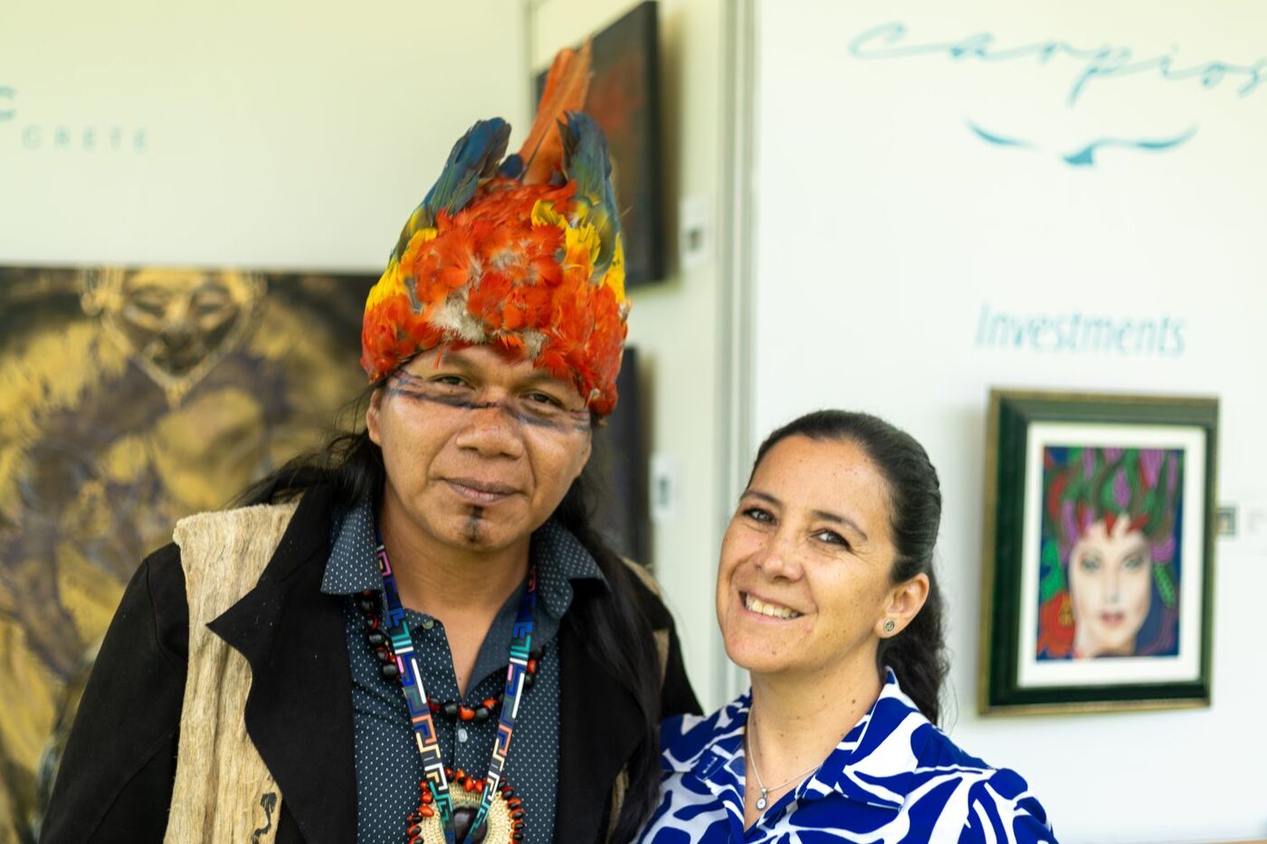 Artista con tocado de plumas junto a la organización